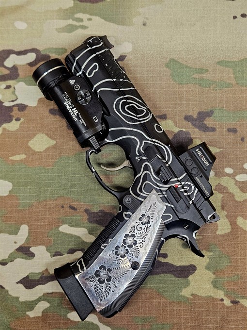 Black pistol with a custom white topographic line pattern and engraved grips